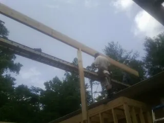 Carpenter setting a ridge beam over a new addition frame — Ice Dam Removal by Roofing Brothers in Stoutsville