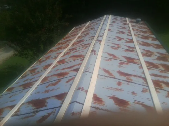 Rusted metal roof panels with new wood purlins before replacement — Storm Damage Roof Repair in Stoutsville by Roofing Brothers