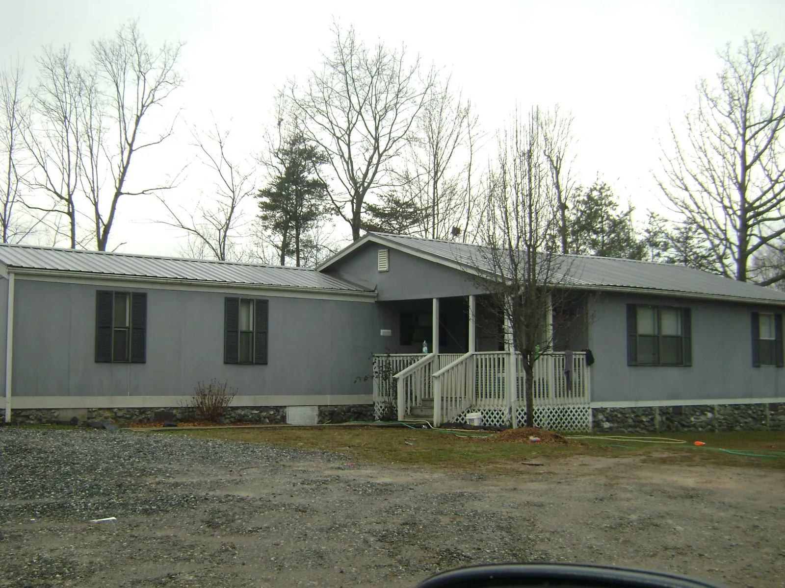 Metal roof over a manufactured home with a covered front porch in Stoutsville