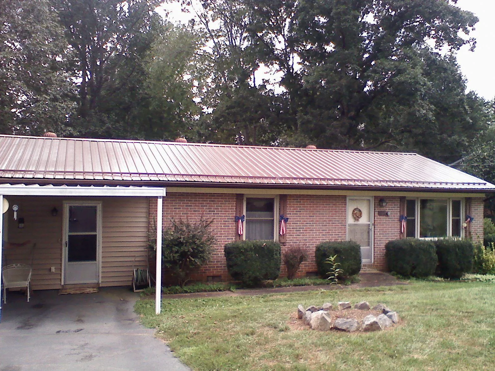 Bronze metal roof and carport on a brick ranch home — Roof Repair work by our crew in Stoutsville